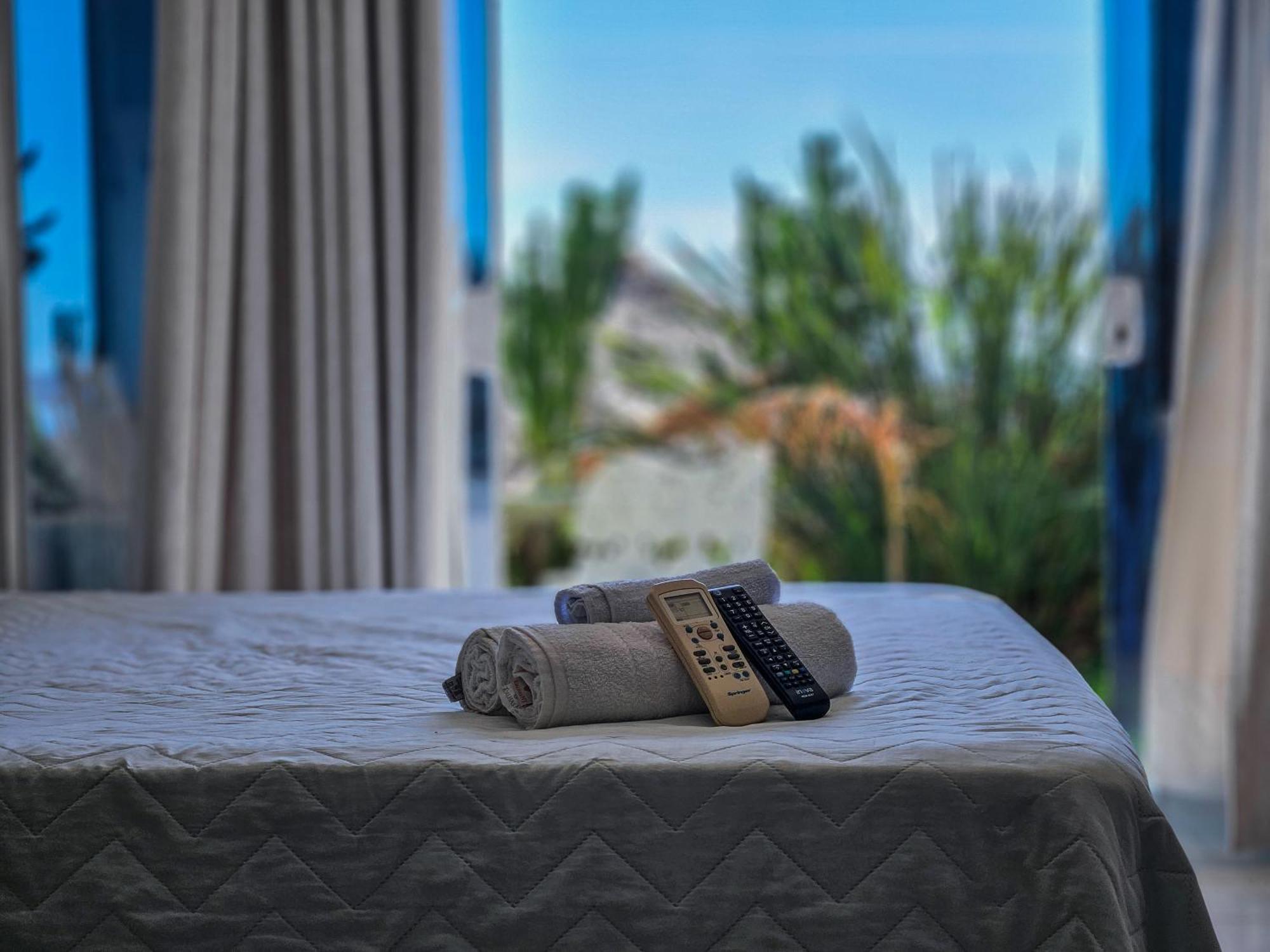 Bliss Hotéis Bella Vista Búzios Extérieur photo A bed with a remote control and a towel